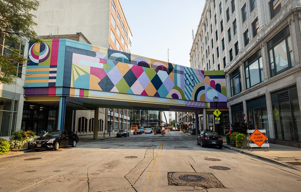 The Kindred mural on a skywalk features vibrant colors.