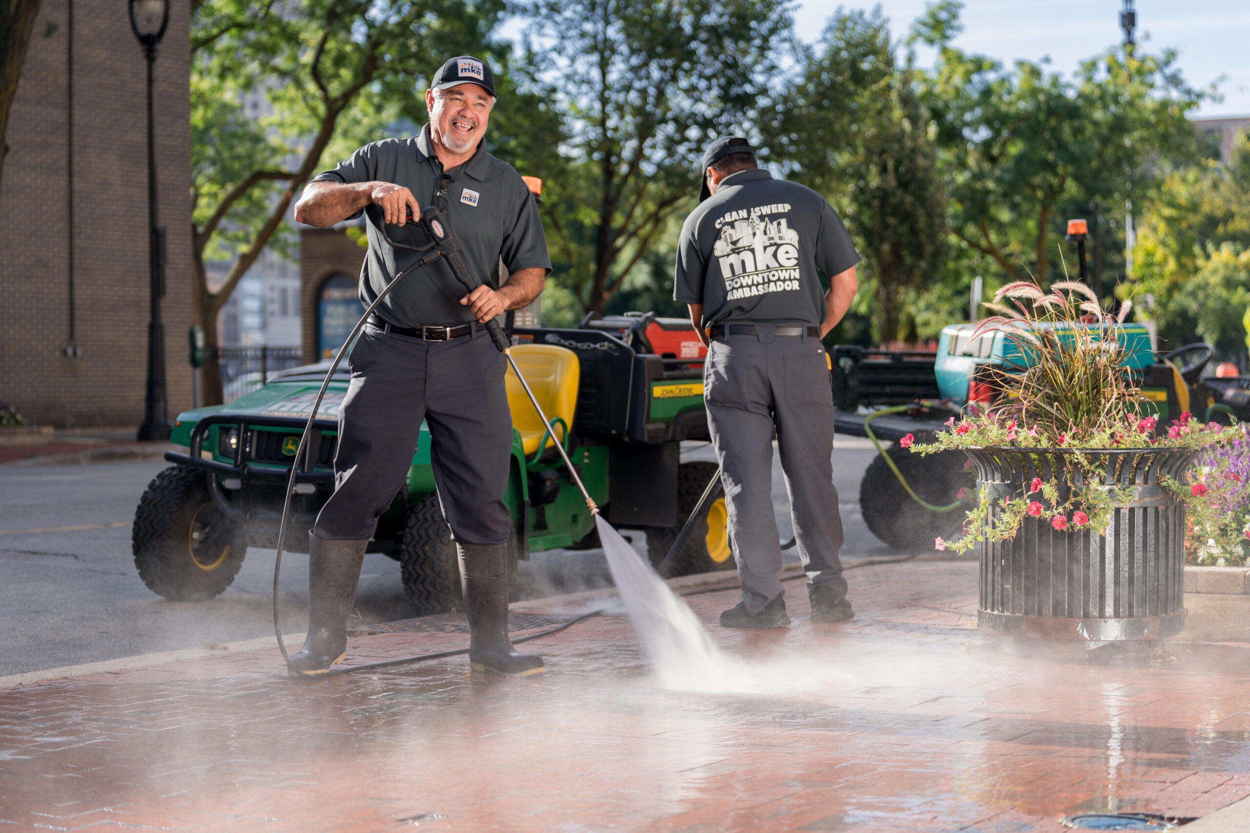 Members of the Clean Sweep Ambassadors power wash the sidewalk.