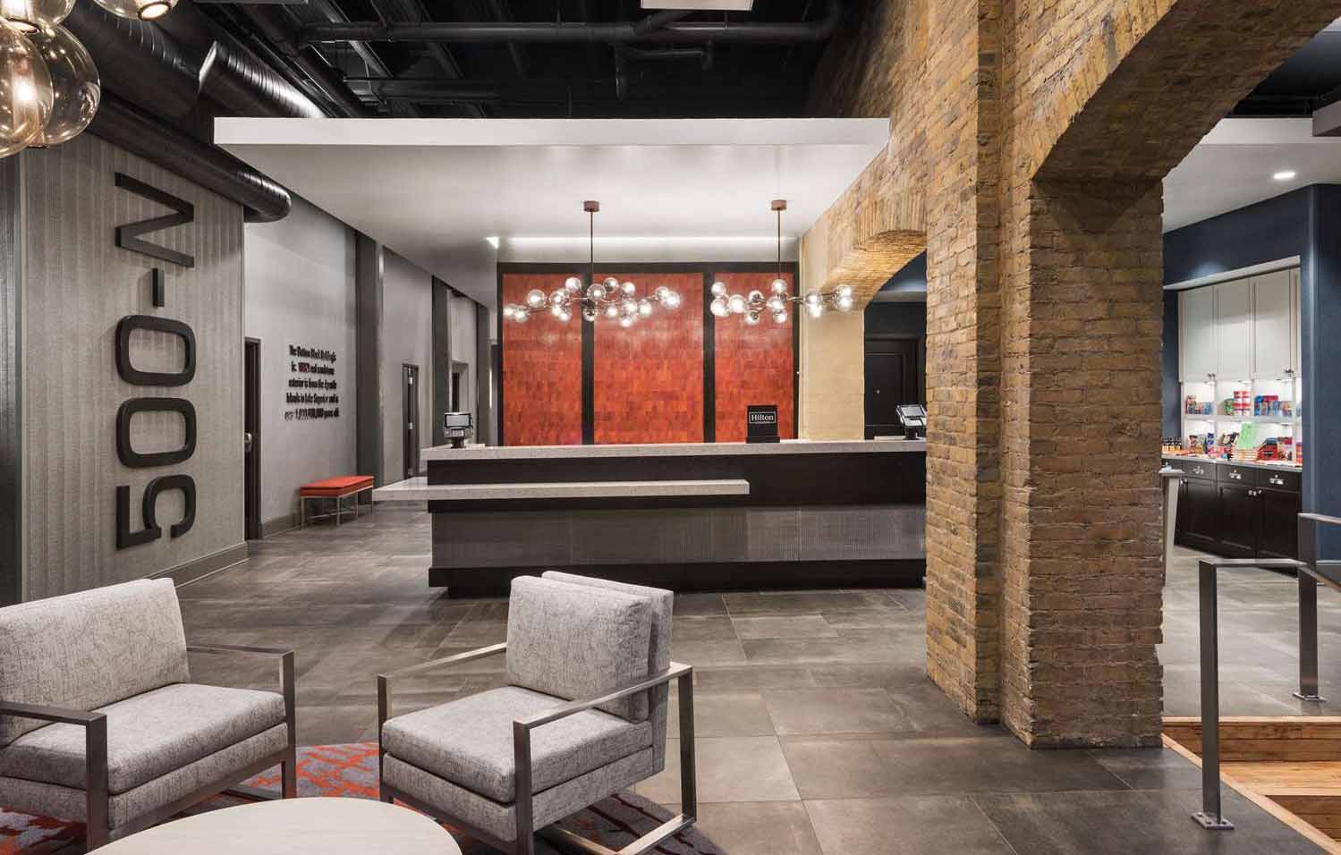 Water St Lot The Homewood Suites lobby features brick columns along with modern design.