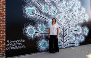 WhatLiftsYou Artist Kelsey Montague poses in front of her mural in Milwaukee.