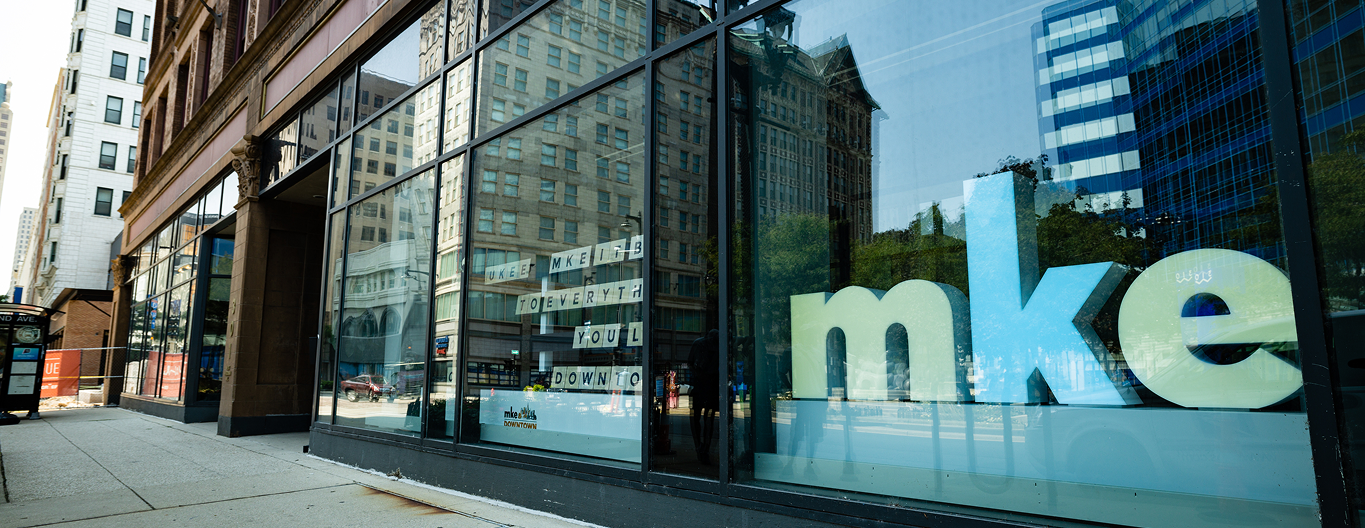 A downtown storefront with the letters MKE in the window.