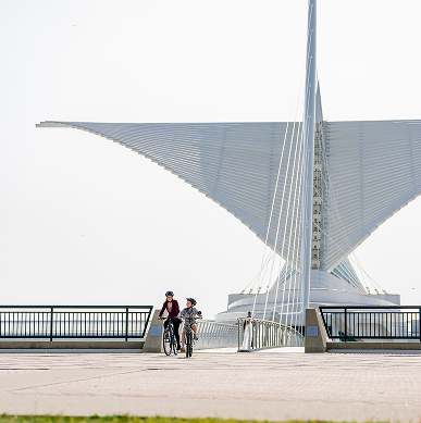Two kids ride their bikes near the Milwaukee Art Museum.
