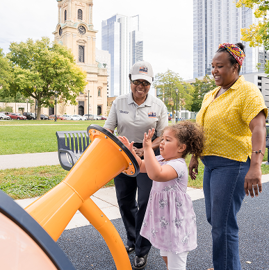 A Public Service Ambassador helps a mom and daughter at the park.