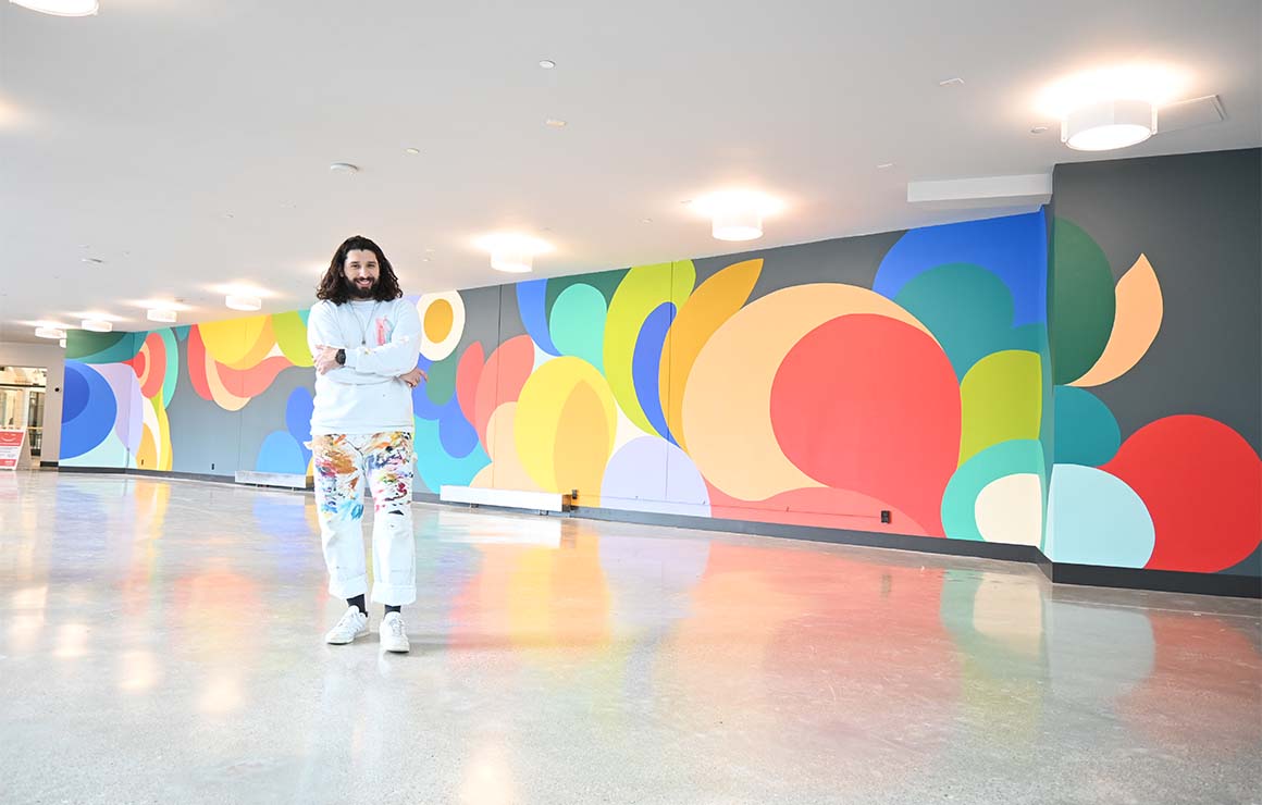 The artist poses with his finished mural.