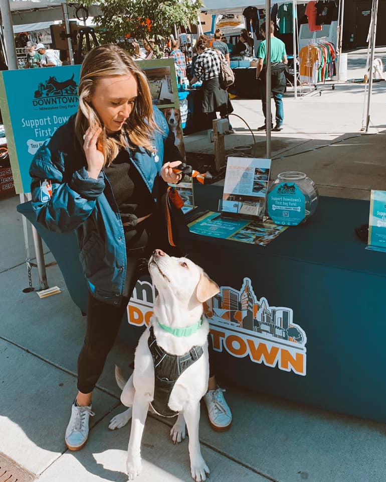 A human and her pup at a downtown event.