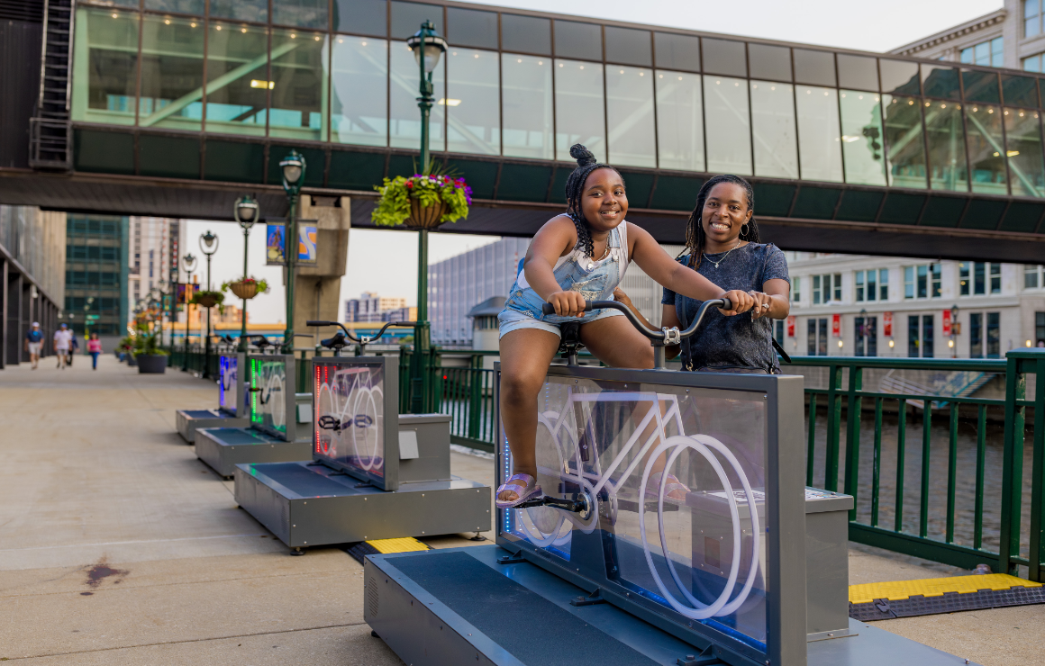 A young girl rights the Light Lane art installation with her mother nearby.