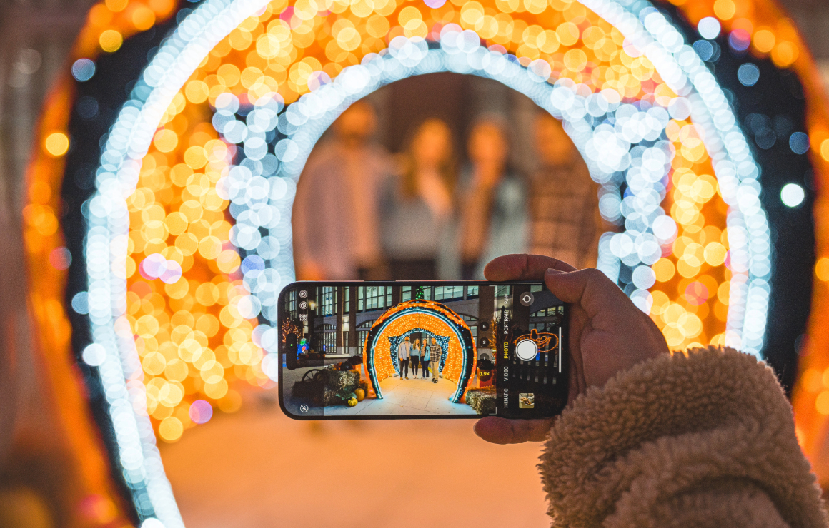 Someone snaps a group photo in front of a Halloween lighting display.