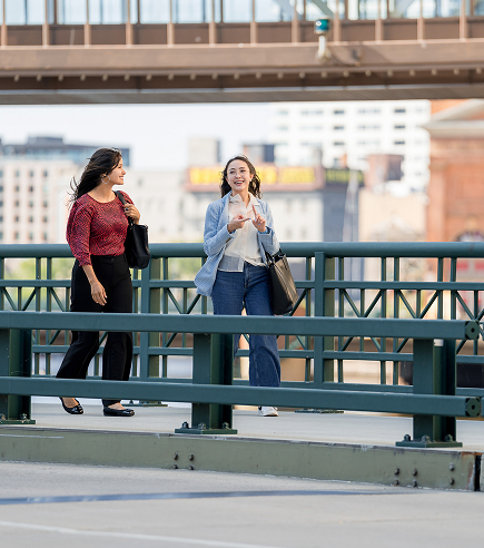 Unparalled Value Two businesswomen walk along the river.