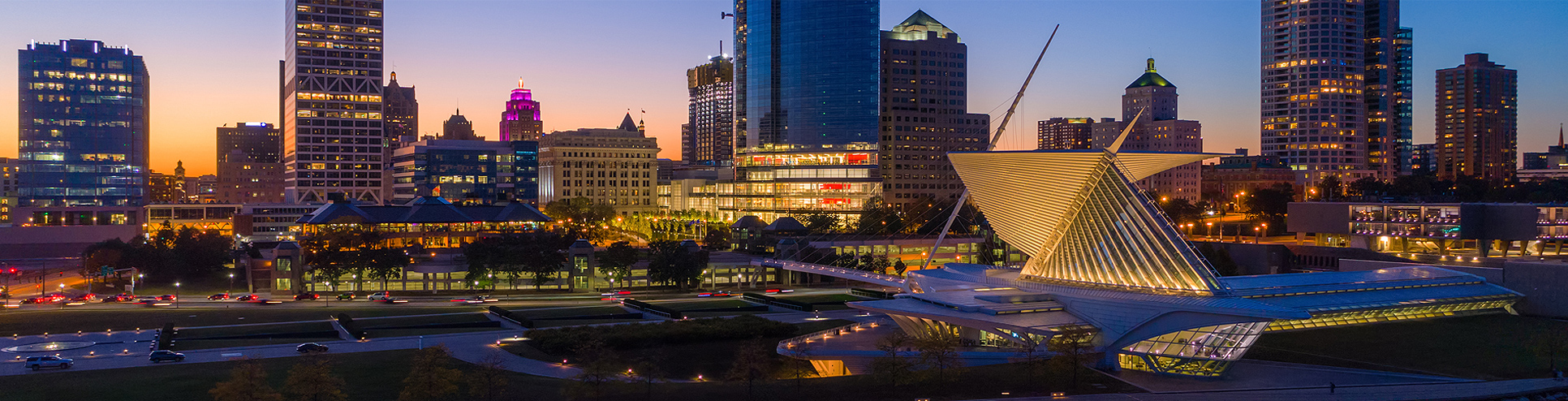 Downtown Milwaukee skyline at dusk, with the sunset behind it.