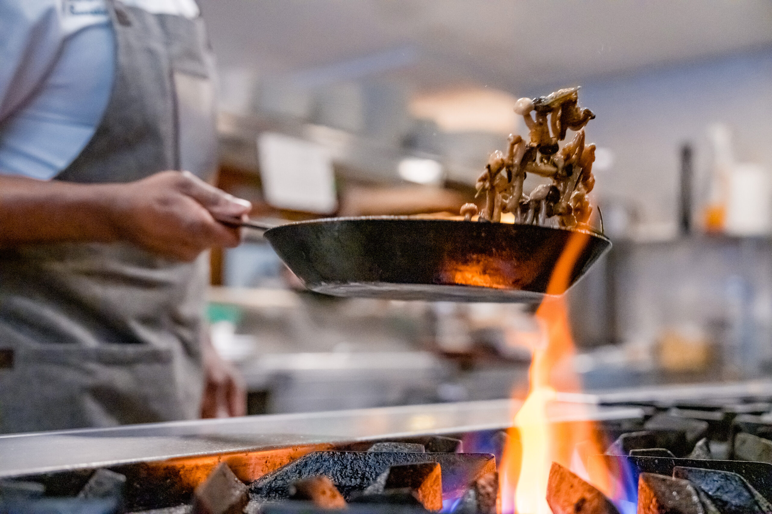 img_MDI_BrandingSenses2023_crFrontRoom_114 A chef cooking over a stove.