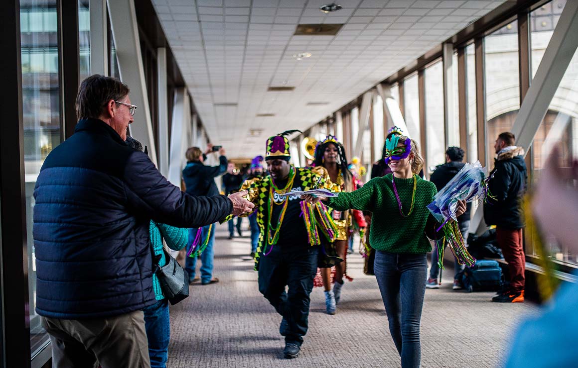 Parade marches hand out beads to parade watchers.